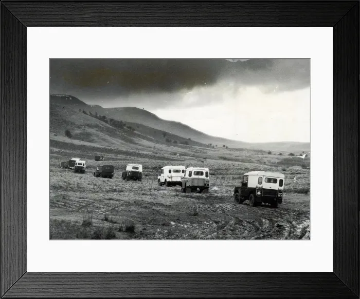 Framed Print : Churning through layers of mud, a line of Land Rovers move cross country towards Framed Print : Churning through layers of mud, a line of Land Rovers move cross country towards