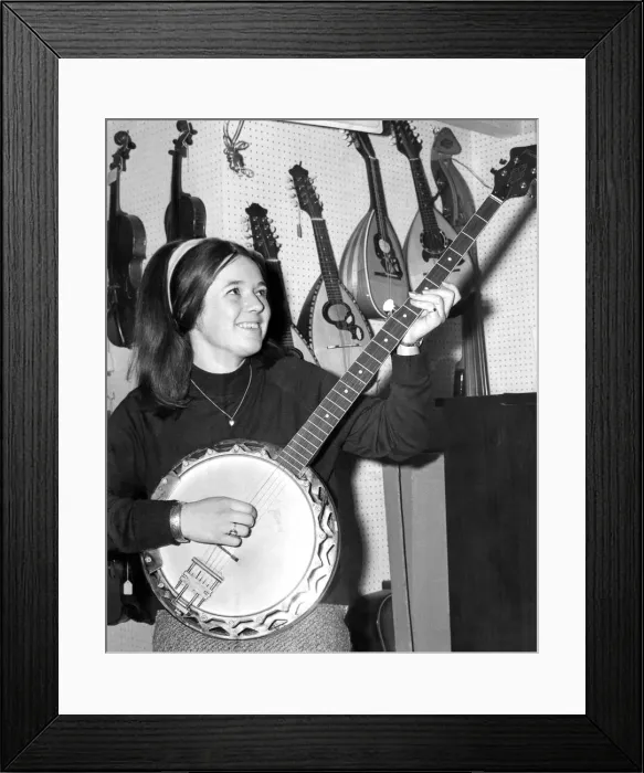 Framed Print : A young girl playing the banjo in September 1968
