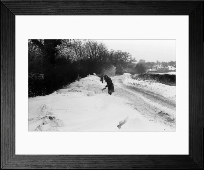 Framed Print : A snowy countryside lane near Coventry. Two men try to clear away the snow Framed Print : A snowy countryside lane near Coventry. Two men try to clear away the snow