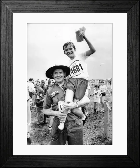Framed Print : The Great North Run 27 June 1982 - Scout leader Glyn Bathgate hoists aloft one of his