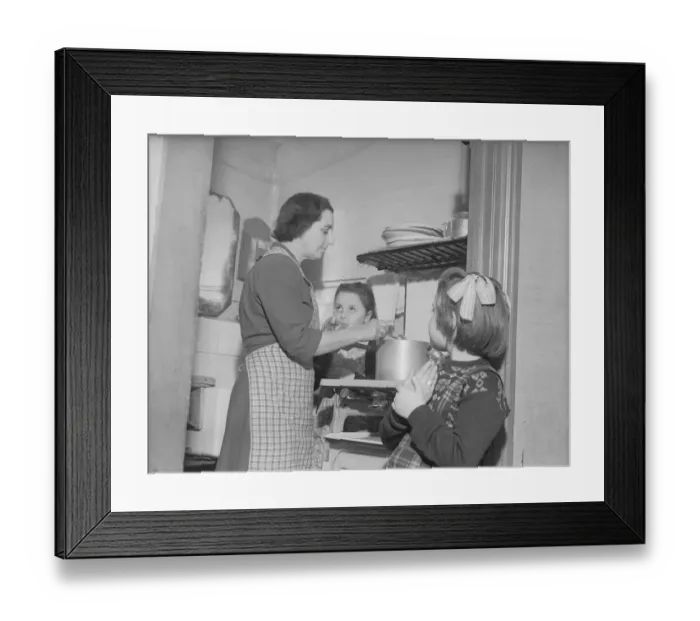 Framed Print : Stay at home mother Mrs Mary Mackenzie seen preparing the evening meal being watched by