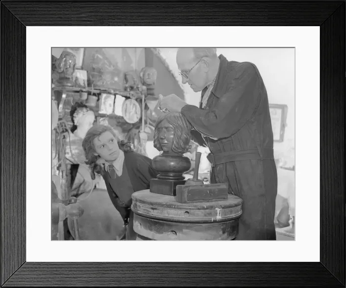 Framed Print : Sculptor William Snell seen here at work in his studio being watch by his schoolgirl