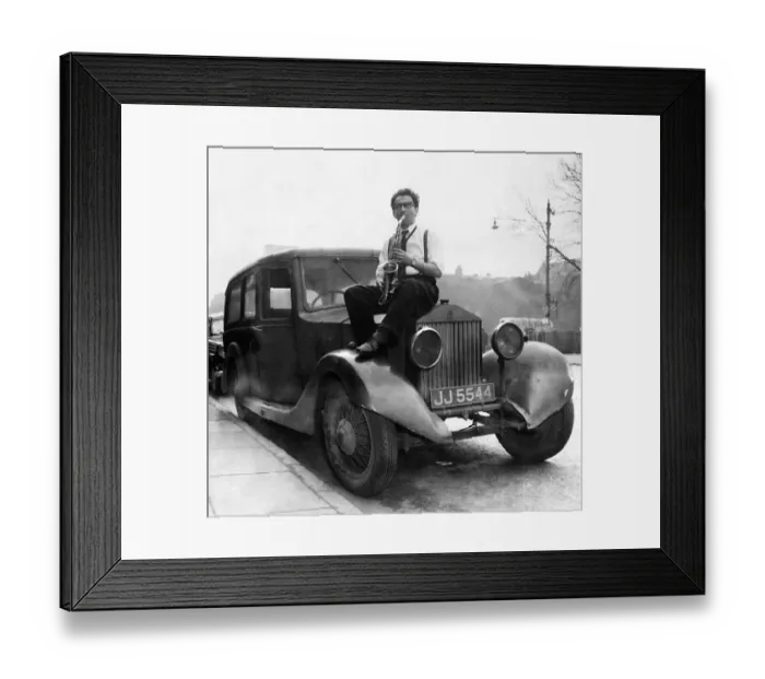 Framed Print : Musician Johnny Roadhouse sitting on the bonnet of a car playing his saxophone