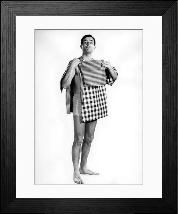 Framed Print : Model Peter Anthony wearing a smock top holding his folded clothes and tea towels Framed Print : Model Peter Anthony wearing a smock top holding his folded clothes and tea towels