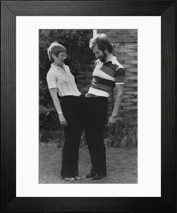 Framed Print : Janet and Tony share a pair of her old size 28 trousers after she lost a large amount of Framed Print : Janet and Tony share a pair of her old size 28 trousers after she lost a large amount of