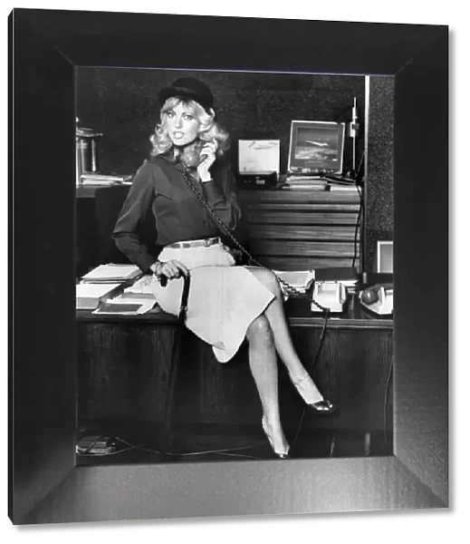 Businesswoman sitting on the desk, talking on the telephone September 1979
