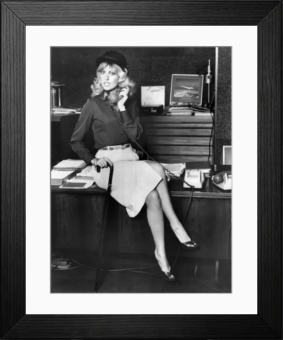 Framed Print : Businesswoman sitting on the desk, talking on the telephone September 1979 Framed Print : Businesswoman sitting on the desk, talking on the telephone September 1979