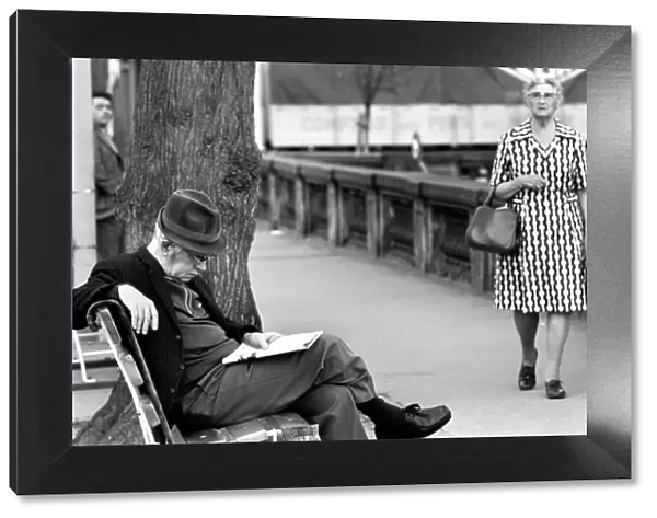 An elderly gent reading his newspaper on a park bench in Luxembourg City