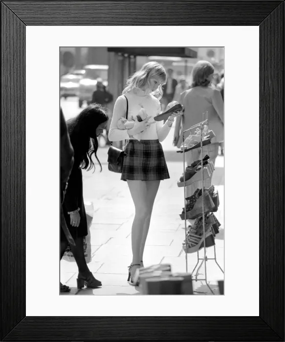 Framed Print : A model wearing a polo neck long sleeved top with tartan skirt shopping for shoes