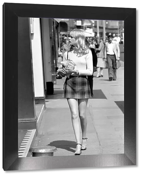 A model wearing a polo neck long sleeved top with tartan skirt shopping for shoes