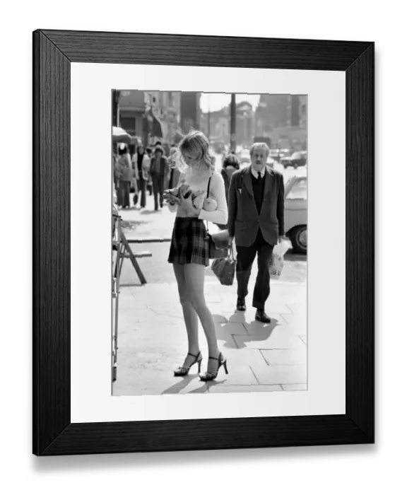 Framed Print : A model wearing a polo neck long sleeved top with tartan skirt shopping for shoes