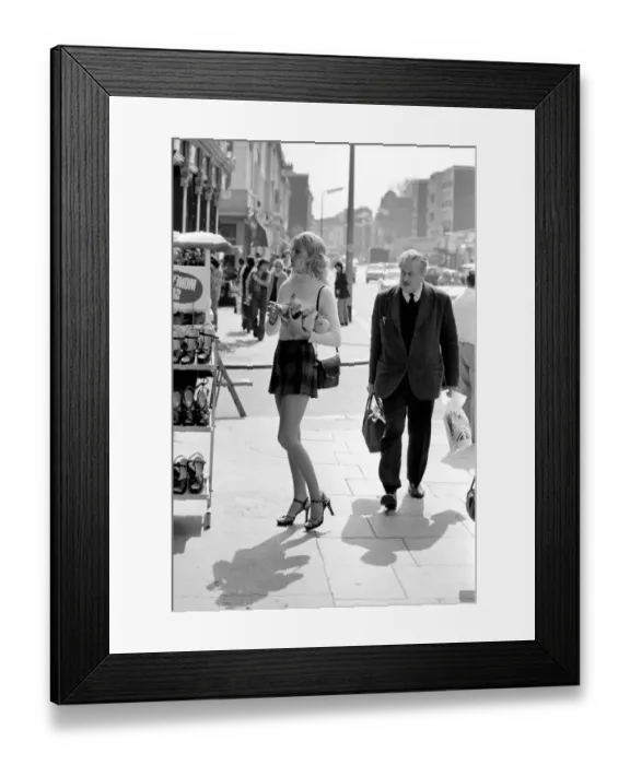 Framed Print : A model wearing a polo neck long sleeved top with tartan skirt shopping for shoes Framed Print : A model wearing a polo neck long sleeved top with tartan skirt shopping for shoes