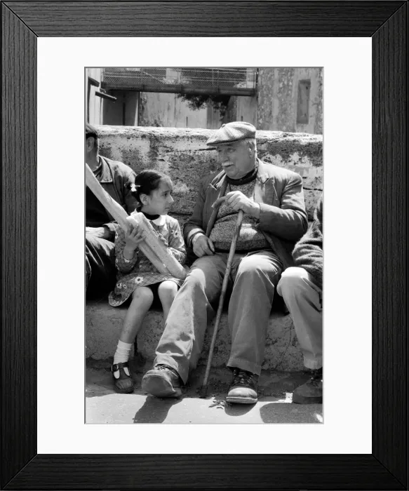 Framed Print : 6 year old Nathalie Rustan with her French loaves of bread talks to pensioner Michel