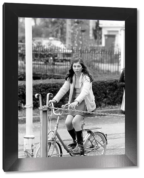A girl riding her bike in a street in a French town April 1975 75-2072-016