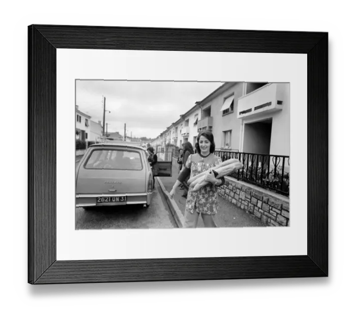 Framed Print : French housewife Mrs. Maria Quaranta after buying the days bread from the delivery car