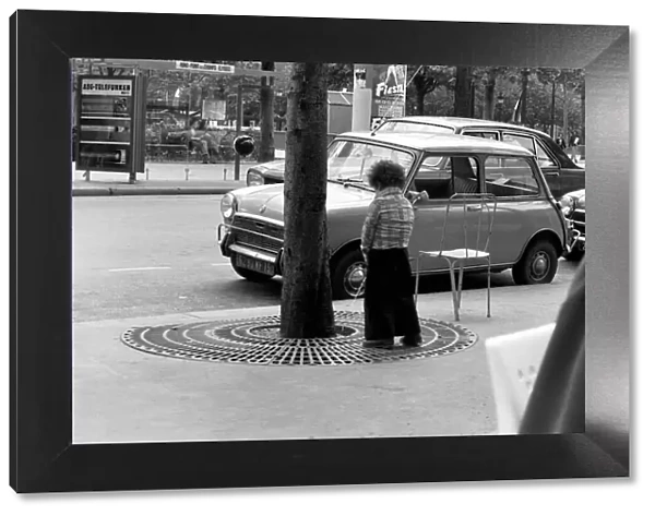 Young boy urinates outside a cafe on the Champs Elysees in Paris, France