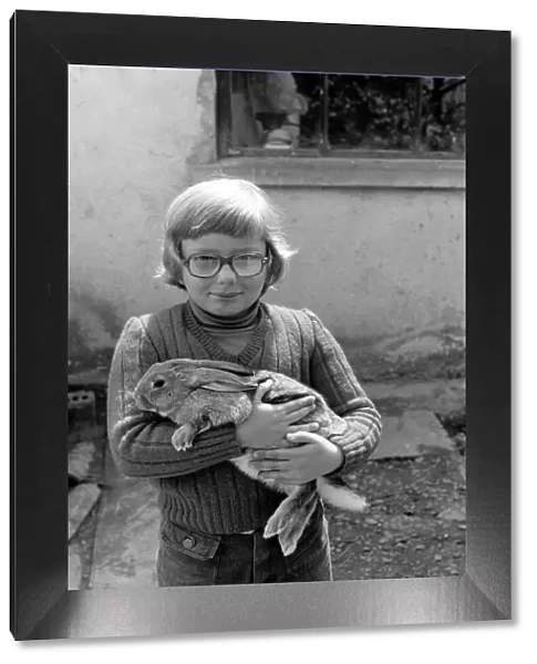 French schoolboy Jean Luc aged 8 with one of the families rabbits that will be due for