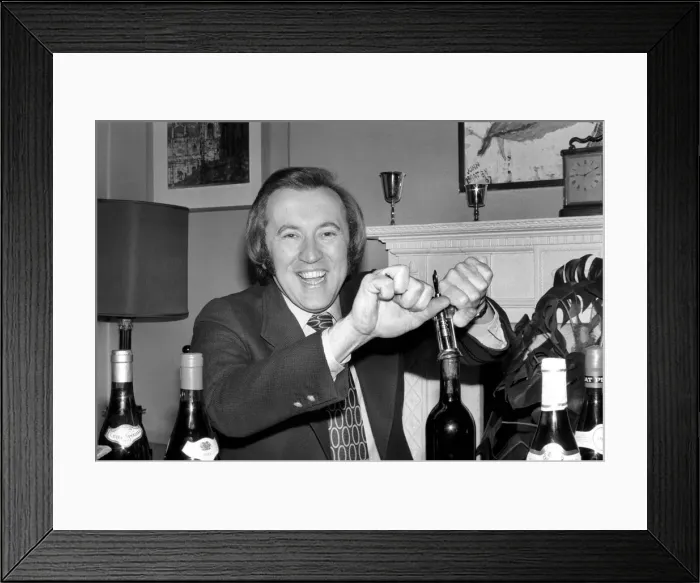 Framed Print : Wine: Mr. David Frost trying to open a bottle of wine at his home. March 1975 75-01338