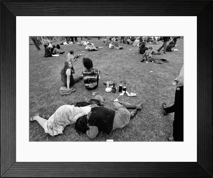 Framed Print : Hyde Park Pop Festival. Couple oblivious to the surroundings embrace by empty wine