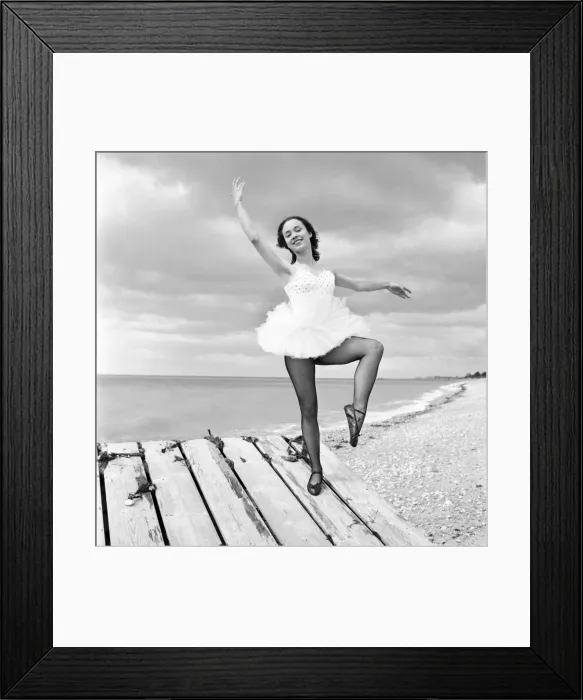Framed Print : Ballerina Anne Youngmen seen here in a tutu practising her dance moves beside the sea
