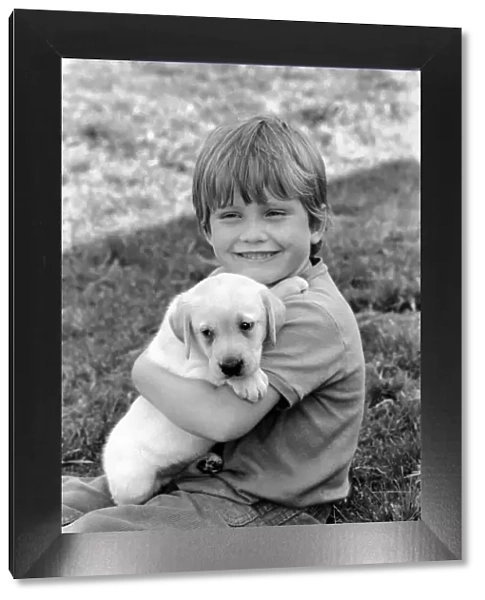 A young boy with a labrador puppy at the Frant Kennels in Hildenborough near Tonbridge