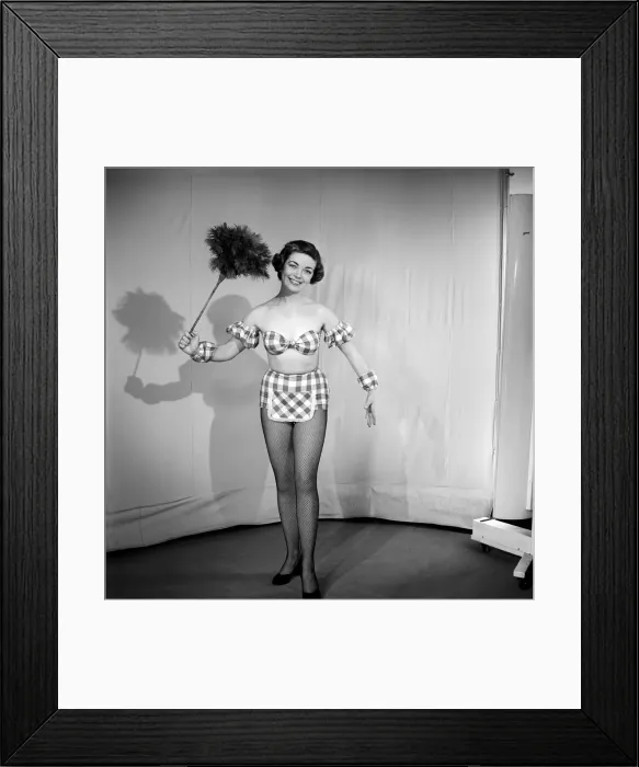 Framed Print : Woman wearing plaid bra and short skirt holding duster. 1959 Framed Print : Woman wearing plaid bra and short skirt holding duster. 1959