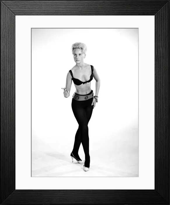 Framed Print : Model Brenda Bartlet dressed as Bond girl holding gun. October 1959