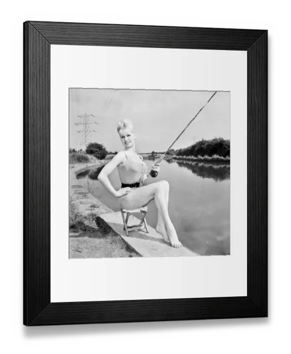 Framed Print : Clothing: Fashion: Beachwear: Model by the river bank fishing. August 1963 E490-013 Framed Print : Clothing: Fashion: Beachwear: Model by the river bank fishing. August 1963 E490-013