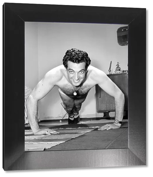 Singer Frankie Vaughan seen here exercising at home. Circa 1957