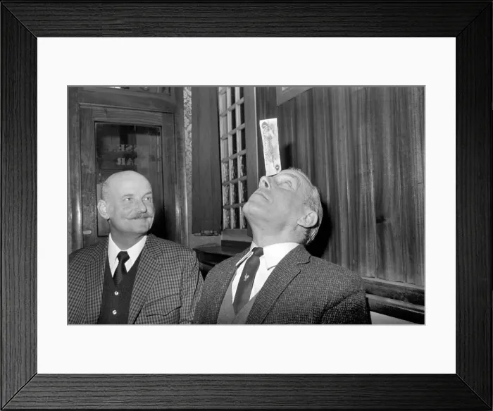 Framed Print : Humour / Unusual. John Mitchell balancing a pound note. February 1975 75-00662-001 Framed Print : Humour / Unusual. John Mitchell balancing a pound note. February 1975 75-00662-001