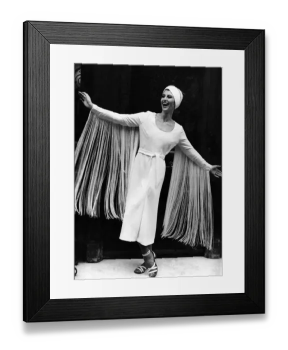 Framed Print : Paula Daly models a midi-length evening dress with eye-catching fringed sleeves