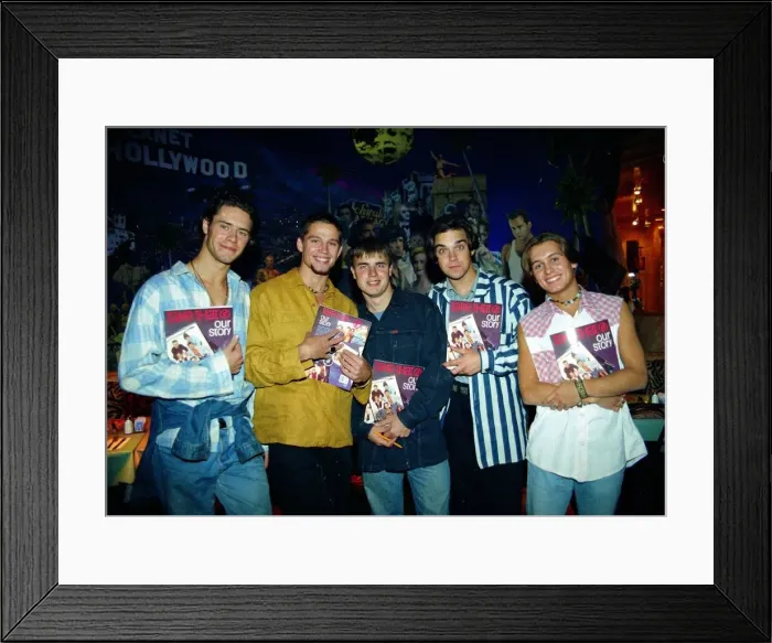 Framed Print : Pop group take that holding copies of their new book beore signing them for fans