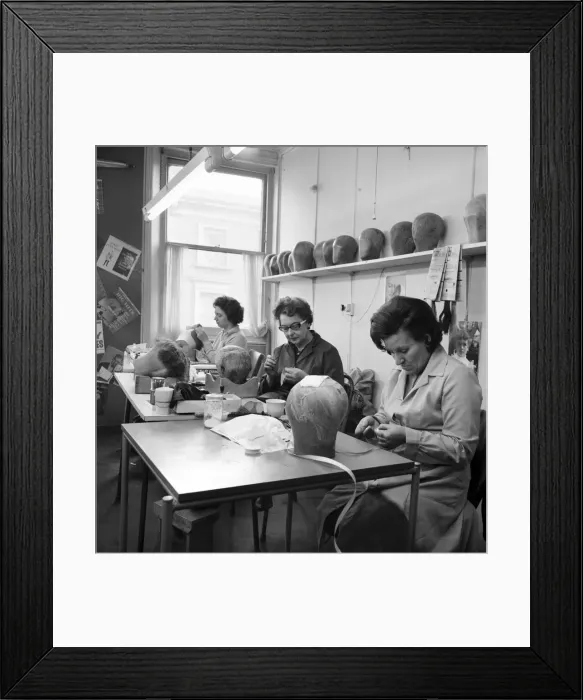 Framed Print : Wigmakers Workshop: Women making wigs whilst in another part of the workshop hair is Framed Print : Wigmakers Workshop: Women making wigs whilst in another part of the workshop hair is