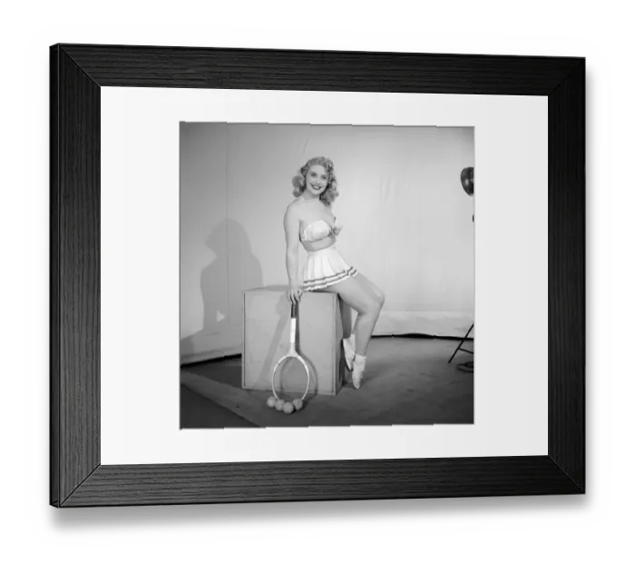 Framed Print : Anyone for tennis? Woman wearing bra, skirt holding tennis racket. 1959