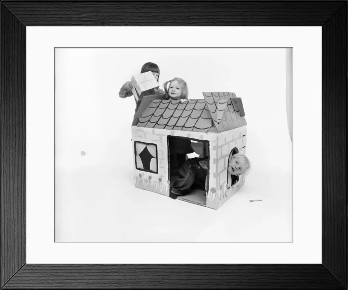 Framed Print : Toys: Children playing with a Wendy house made out of cardboard Framed Print : Toys: Children playing with a Wendy house made out of cardboard
