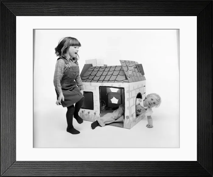 Framed Print : Toys: Children playing with a Wendy house made out of cardboard Framed Print : Toys: Children playing with a Wendy house made out of cardboard