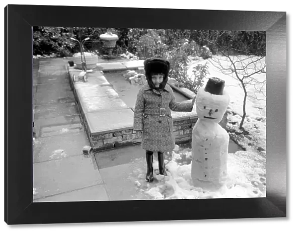 A girl with the snowman she built during the last fall of snow. March 1975 75-1706-011