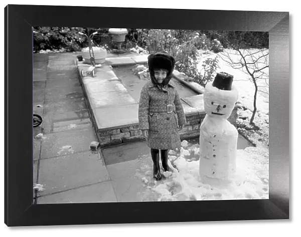A girl with the snowman she built during the last fall of snow. March 1975 75-1706-012