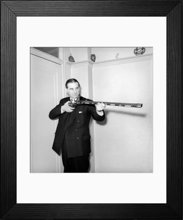 Framed Print : Pip Roberts a collector of antique firearms, seen here demonstrating a flintlock rifle