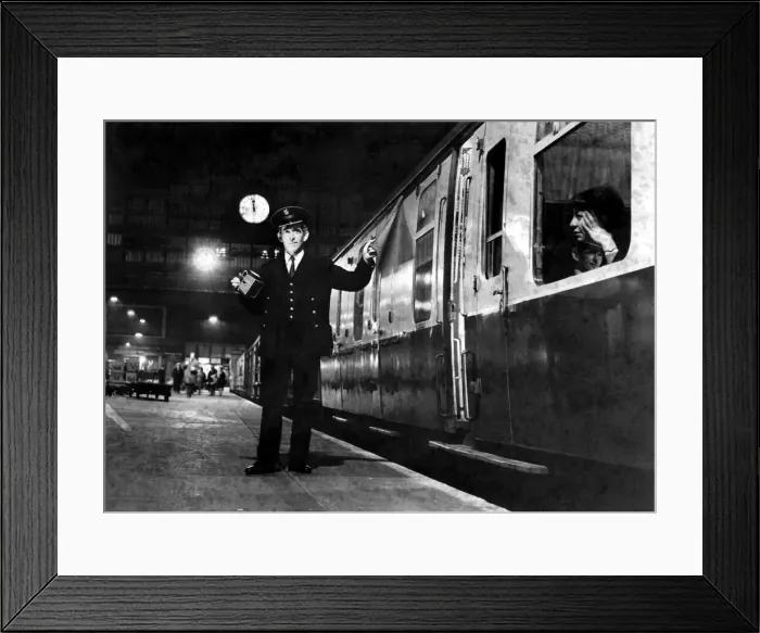 Framed Print : A guard signals to the driver that the train can depart the station Framed Print : A guard signals to the driver that the train can depart the station