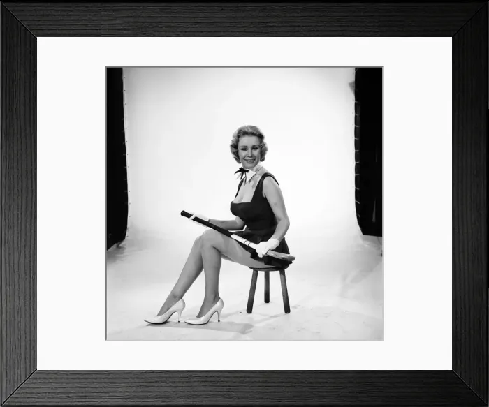 Framed Print : Rita Royce modelling sports kit with hockey stick. Circa 1959