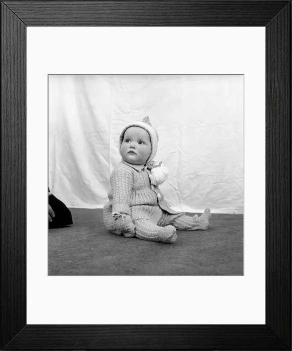 Framed Print : Clothing: Children: Babies: Baby wearing a knitted suit with matching hood and mittens