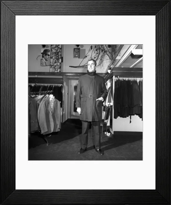 Framed Print : Male model wearing raincoat in menswear department. 1966 Framed Print : Male model wearing raincoat in menswear department. 1966