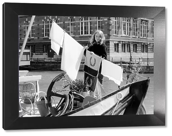 A woman living on a boat in Rotterdam, hanging her laundry on the washing line on board