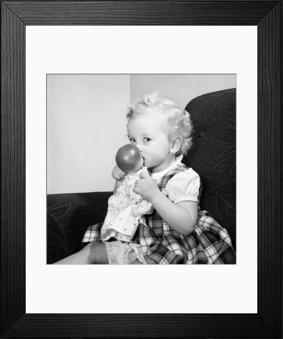 Framed Print : Small girl reading her book also seen with her dolls and violin. 1955 A138-001 Framed Print : Small girl reading her book also seen with her dolls and violin. 1955 A138-001