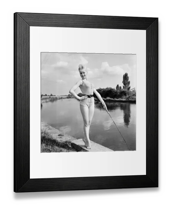Framed Print : Clothing: Fashion: Beachwear: Model by the river bank fishing. August 1963 E490-009 Framed Print : Clothing: Fashion: Beachwear: Model by the river bank fishing. August 1963 E490-009