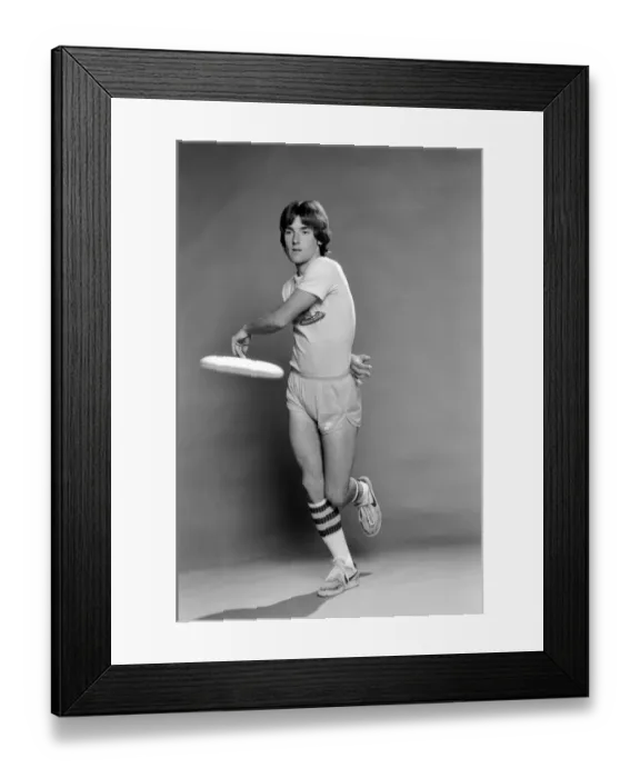 Framed Print : A man performing exercises with a frisbee. June 1980