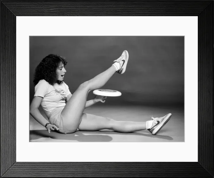 Framed Print : A woman performing exercises with a frisbee. June 1980