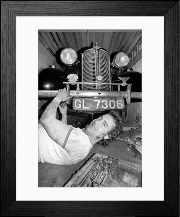 Framed Print : Mechanic underneath a car, making repairs April 1975 75-02158-010 Framed Print : Mechanic underneath a car, making repairs April 1975 75-02158-010