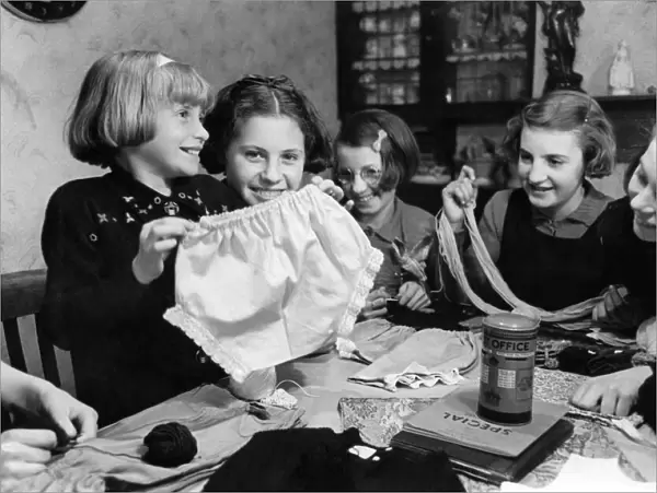 Young girls showing off one of six pairs of knickers that they made from an old night